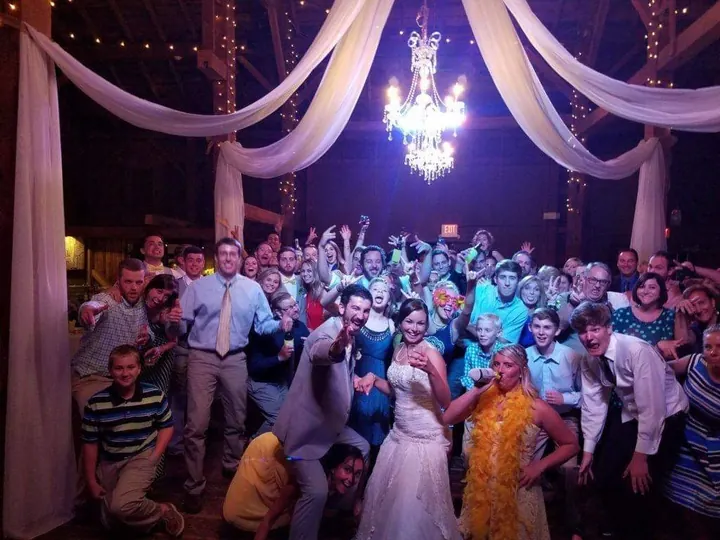 Wedding guests posing together beneath a chandelier