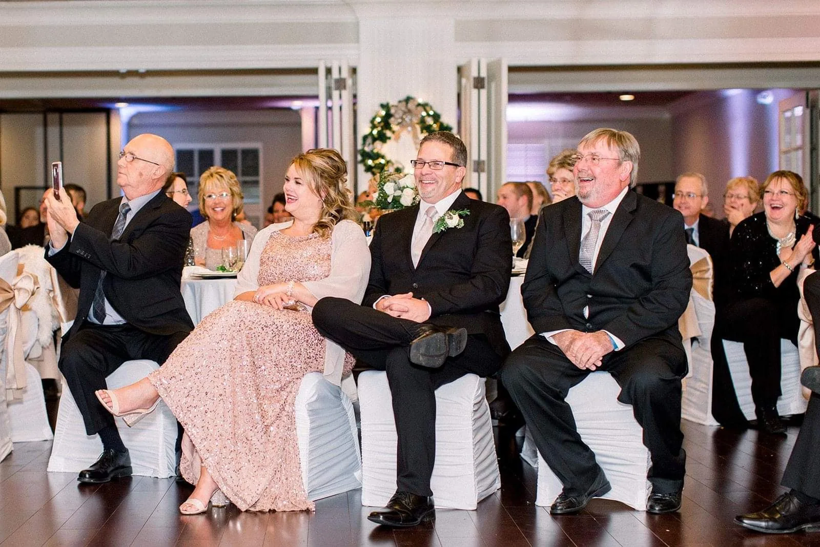 Guests laughing during a wedding reception program
